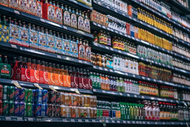 A well-stocked store aisle in Pennsylvania features shelves filled with a variety of bottled beverages, including soft drinks, juices, and energy drinks, organized by brand and flavor. The shelves are neatly arranged, showcasing colorful labels and packaging. Remember what to do if you witness or experience a supermarket accident here.