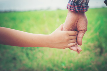 child's hand holding dad's